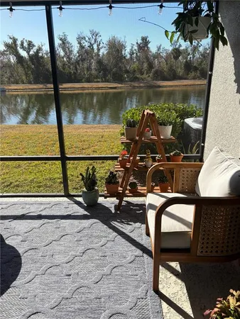 a view of a lake with a floor to ceiling window next to a yard