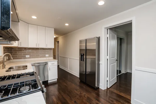 a kitchen with a refrigerator sink and wooden floor