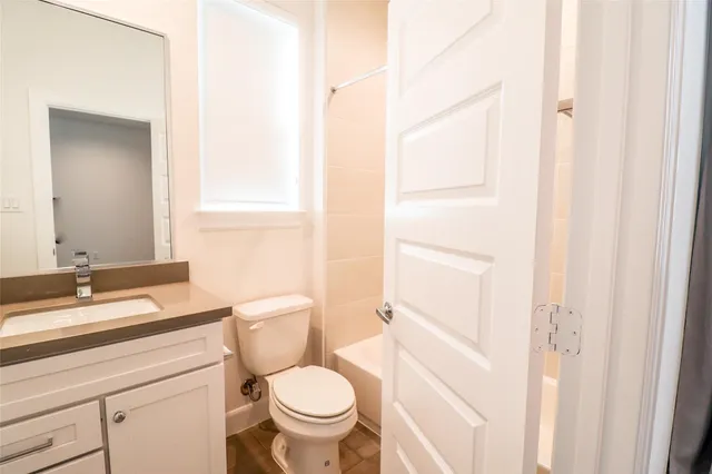 a bathroom with a granite countertop sink toilet and mirror