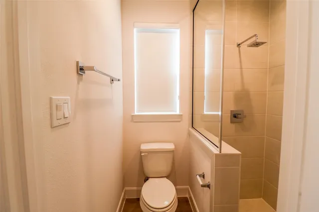 a bathroom with a toilet and a shower
