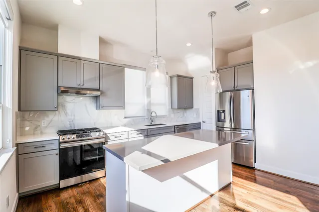a kitchen with kitchen island a stove a sink and a refrigerator