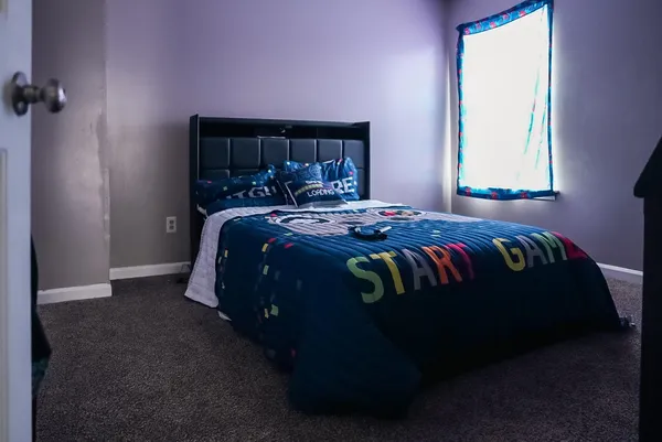a bed sitting in a bedroom next to a window