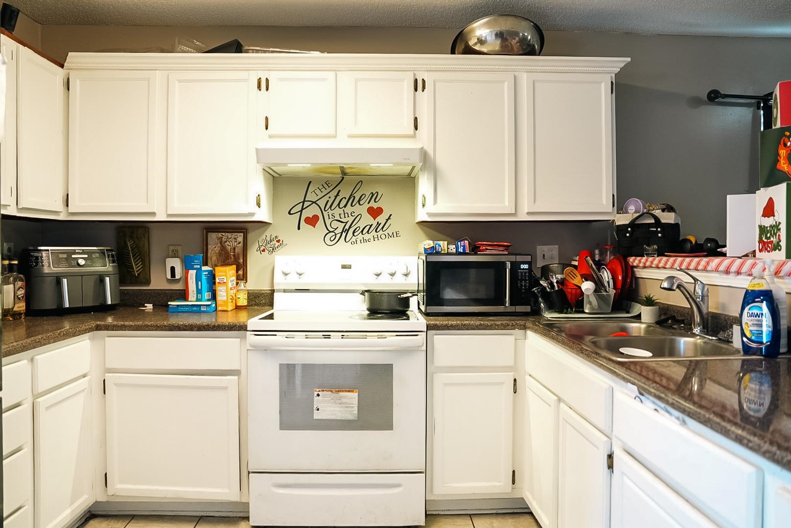 936 Porter Street Memphis, TN 38126 - Photo 5 of 22 Kitchen with white electric range, white cabinetry, stainless steel microwave, dark countertops, and a textured ceiling