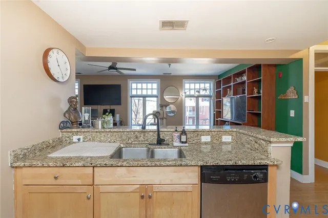 a kitchen with granite countertop a sink a stove and cabinets