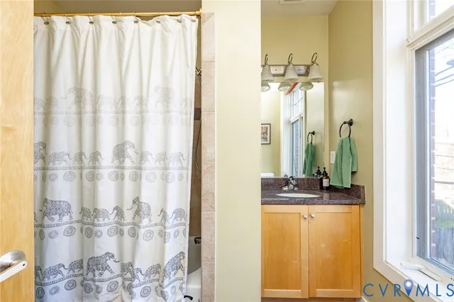 a bathroom with a granite countertop sink and a mirror