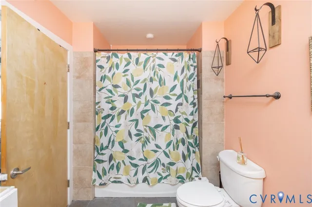 a white toilet sitting next to a shower curtain