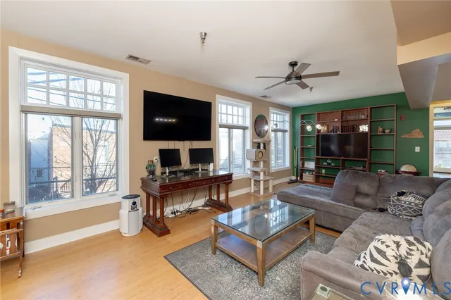 a living room with furniture a flat screen tv and a large window