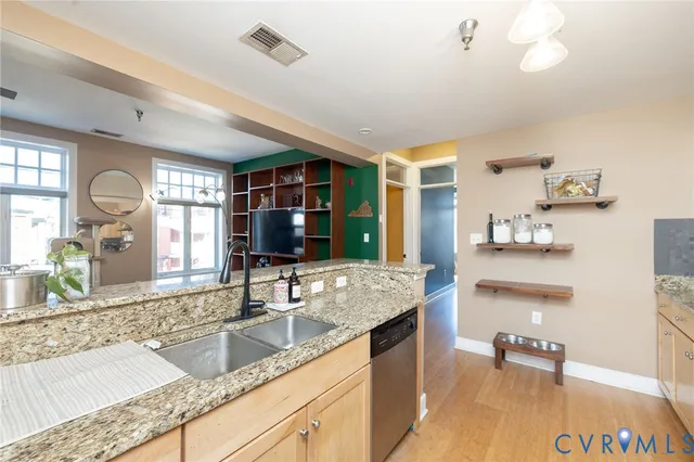 a large kitchen with granite countertop a sink and a large mirror next to a window