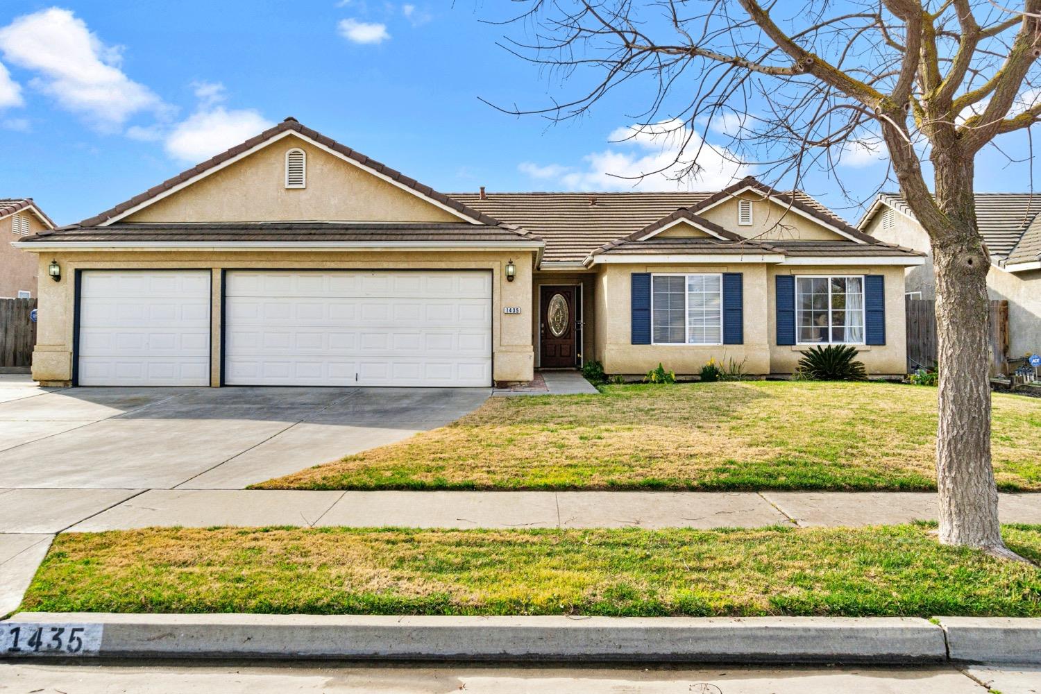 a front view of a house with a yard and potted plants