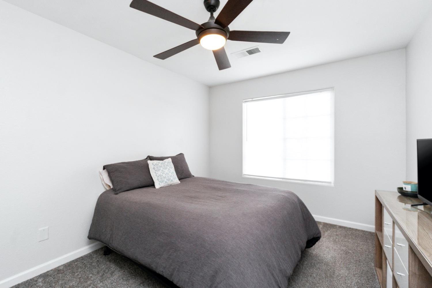 1435 Summerwind Drive Lemoore, CA 93245 - Photo 14 of 32 a bedroom with a bed and a flat tv screen on the dresser