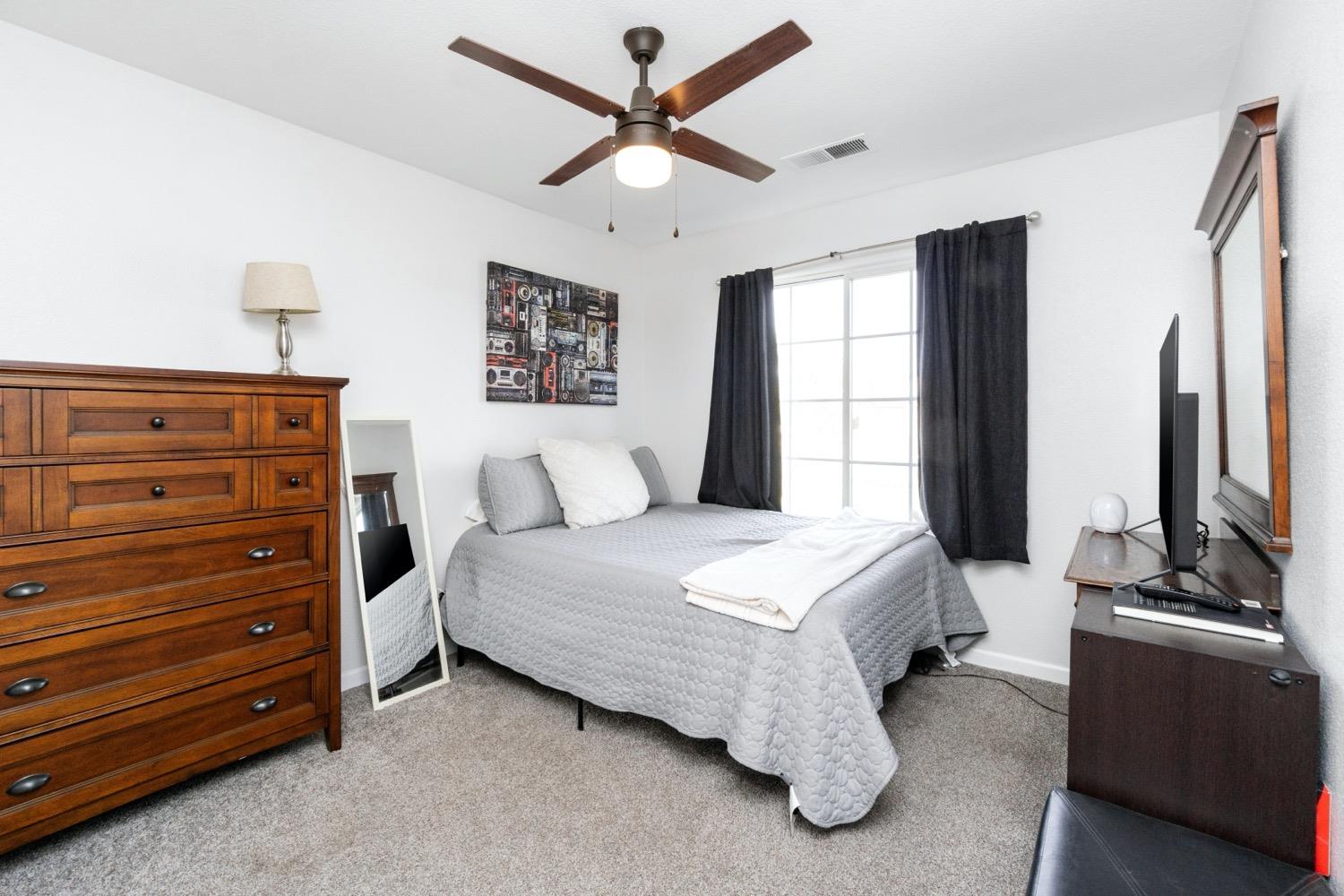 1435 Summerwind Drive Lemoore, CA 93245 - Photo 16 of 32 a bedroom with a bed and a flat screen tv