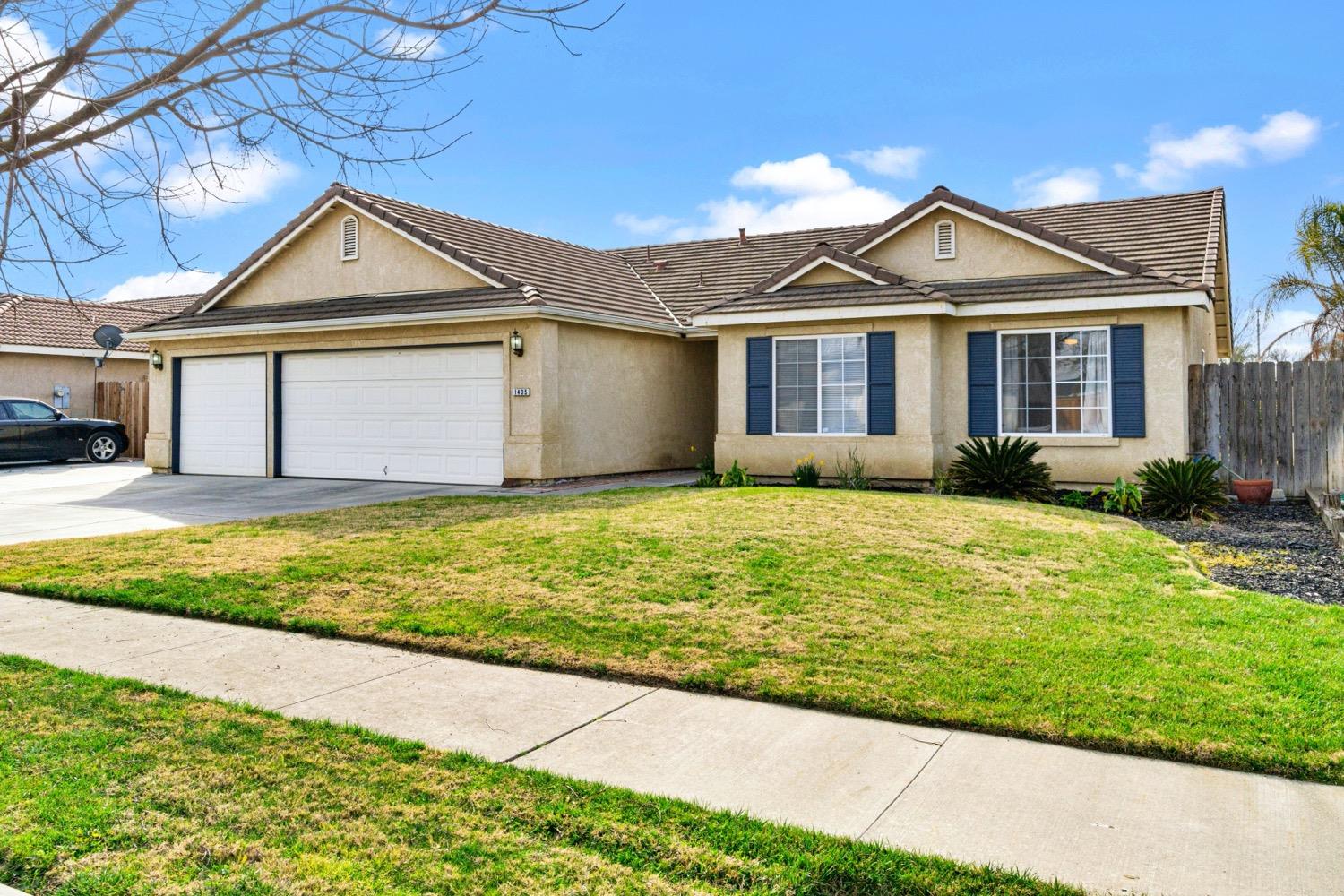 1435 Summerwind Drive Lemoore, CA 93245 - Photo 2 of 32 a front view of a house with garden