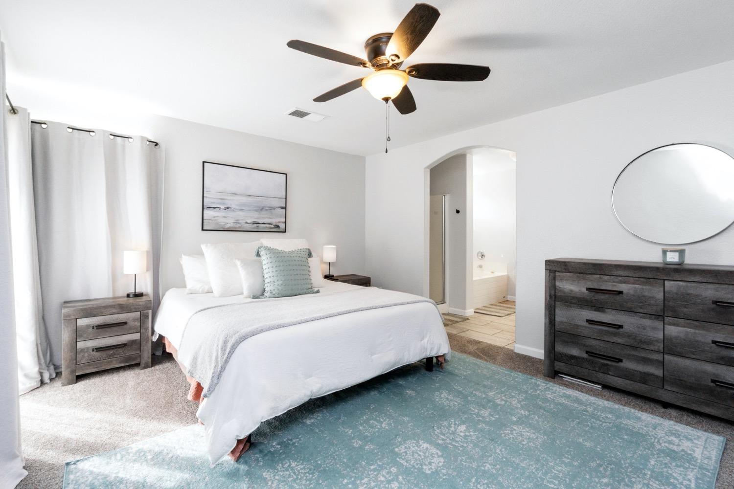 1435 Summerwind Drive Lemoore, CA 93245 - Photo 21 of 32 a bedroom with a bed a ceiling fan and a dresser