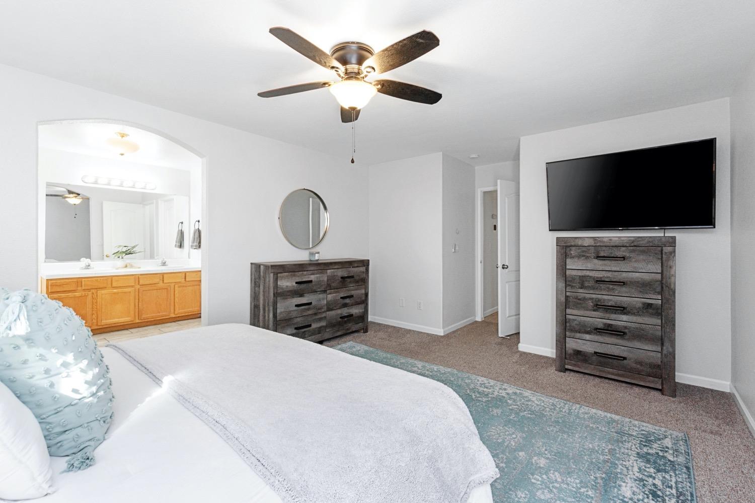 1435 Summerwind Drive Lemoore, CA 93245 - Photo 22 of 32 a spacious bedroom with a bed and a television in it