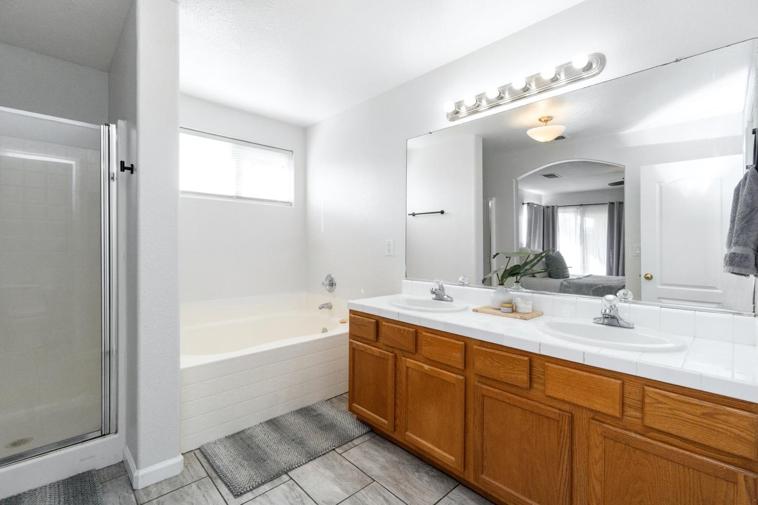 1435 Summerwind Drive Lemoore, CA 93245 - Photo 24 of 32 a spacious bathroom with a double vanity sink mirror and bathtub