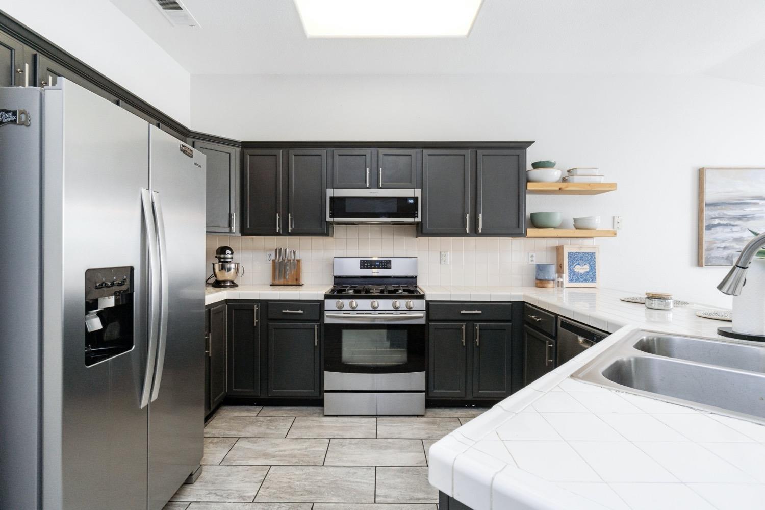 1435 Summerwind Drive Lemoore, CA 93245 - Photo 9 of 32 a kitchen with a sink a stove and refrigerator