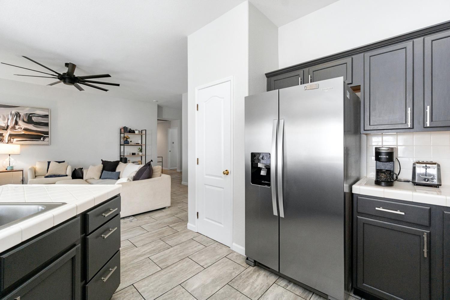 1435 Summerwind Drive Lemoore, CA 93245 - Photo 10 of 32 a kitchen with a refrigerator and a sink