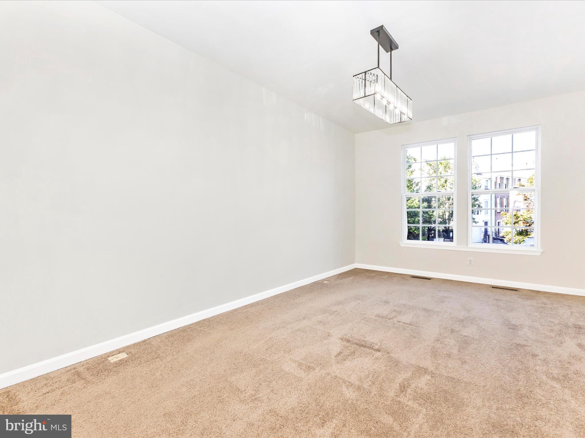 7096 Water Oak Road, Unit 121 Elkridge, MD 21075 - Photo 12 of 46 an empty room with windows and chandelier fan