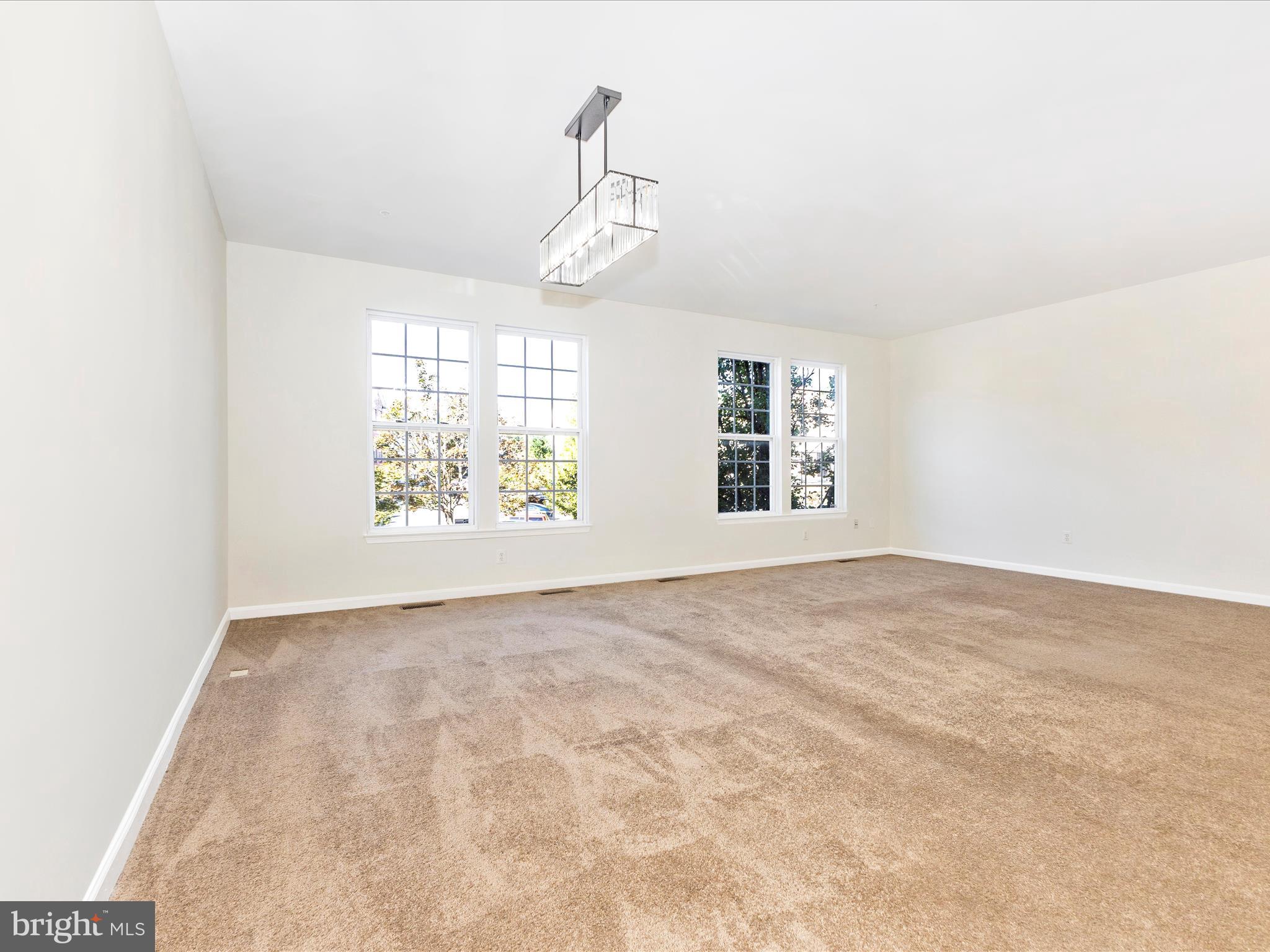 7096 Water Oak Road, Unit 121 Elkridge, MD 21075 - Photo 15 of 46 an empty room with windows and chandelier fan