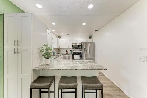 a kitchen with kitchen island a counter top space stainless steel appliances and cabinets