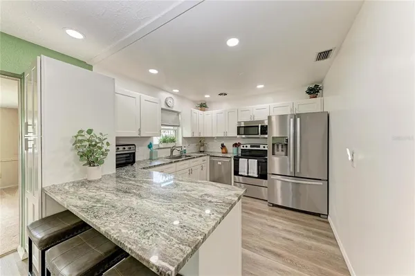 a kitchen with stainless steel appliances a refrigerator stove and microwave