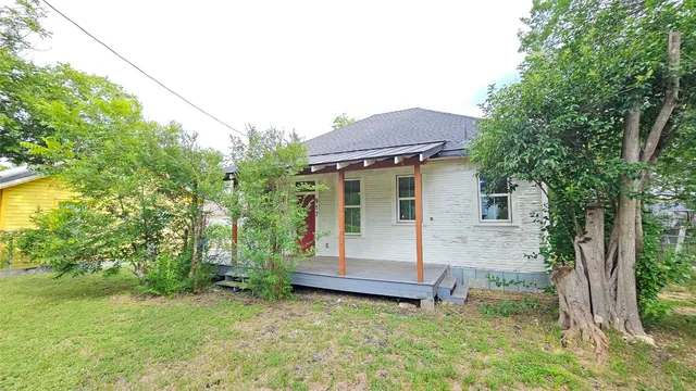 a view of a house with backyard and a tree