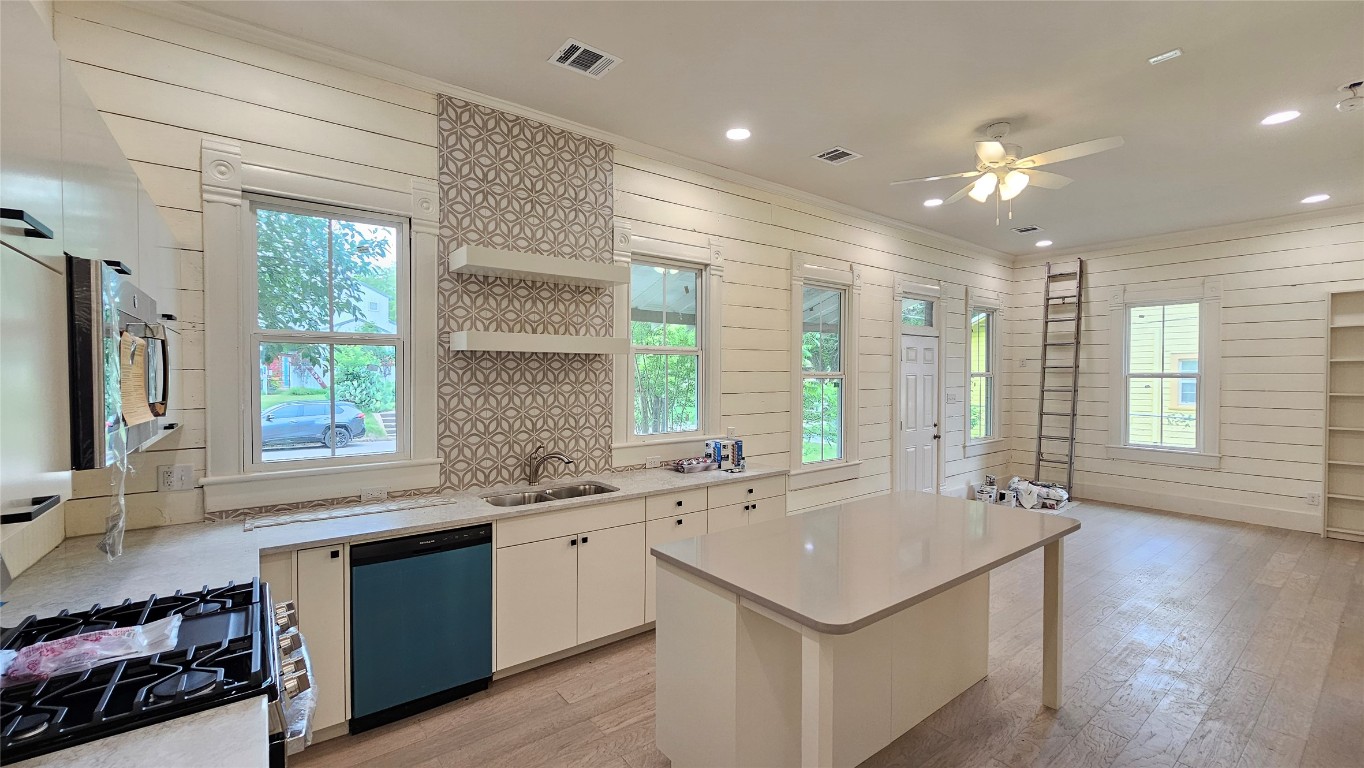 917 West 6th Street Taylor, TX 76574 - Photo 4 of 11 a kitchen with a sink stove and cabinets