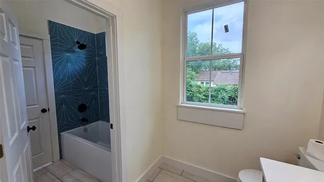 a bathroom with a tub a window and a sink