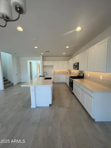 a large kitchen with stainless steel appliances lots of counter space and a sink