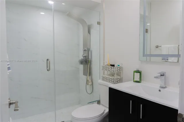 a bathroom with a granite countertop sink toilet and shower