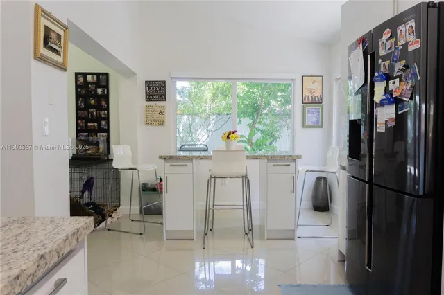 a kitchen with white cabinets and refrigerator