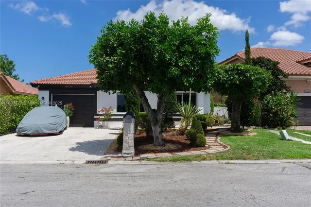 a front view of a house with garden and plants