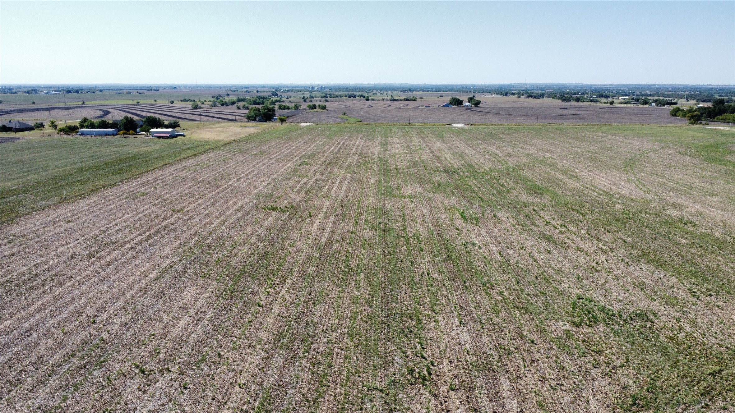 3c Airville Road Temple, TX 76501 - Photo 12 of 12 Vast agricultural acreage stretches toward the horizon under a clear blue sky.