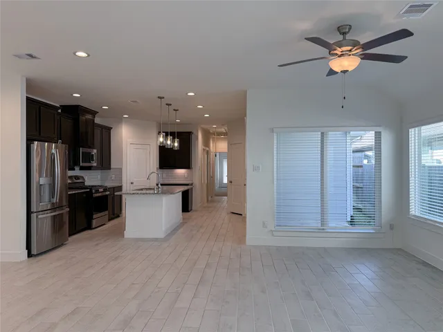 an open kitchen with kitchen island and stainless steel appliances