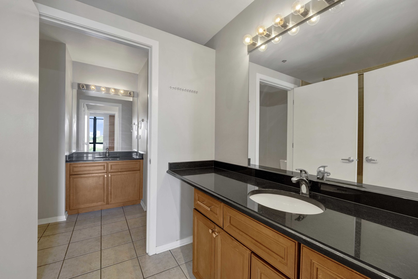 1525 South Sangamon Street, Unit 504 Chicago, IL 60608 - Photo 23 of 32 a bathroom with a granite countertop sink and a mirror