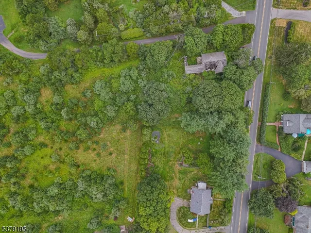 an aerial view of residential house with outdoor space and trees all around