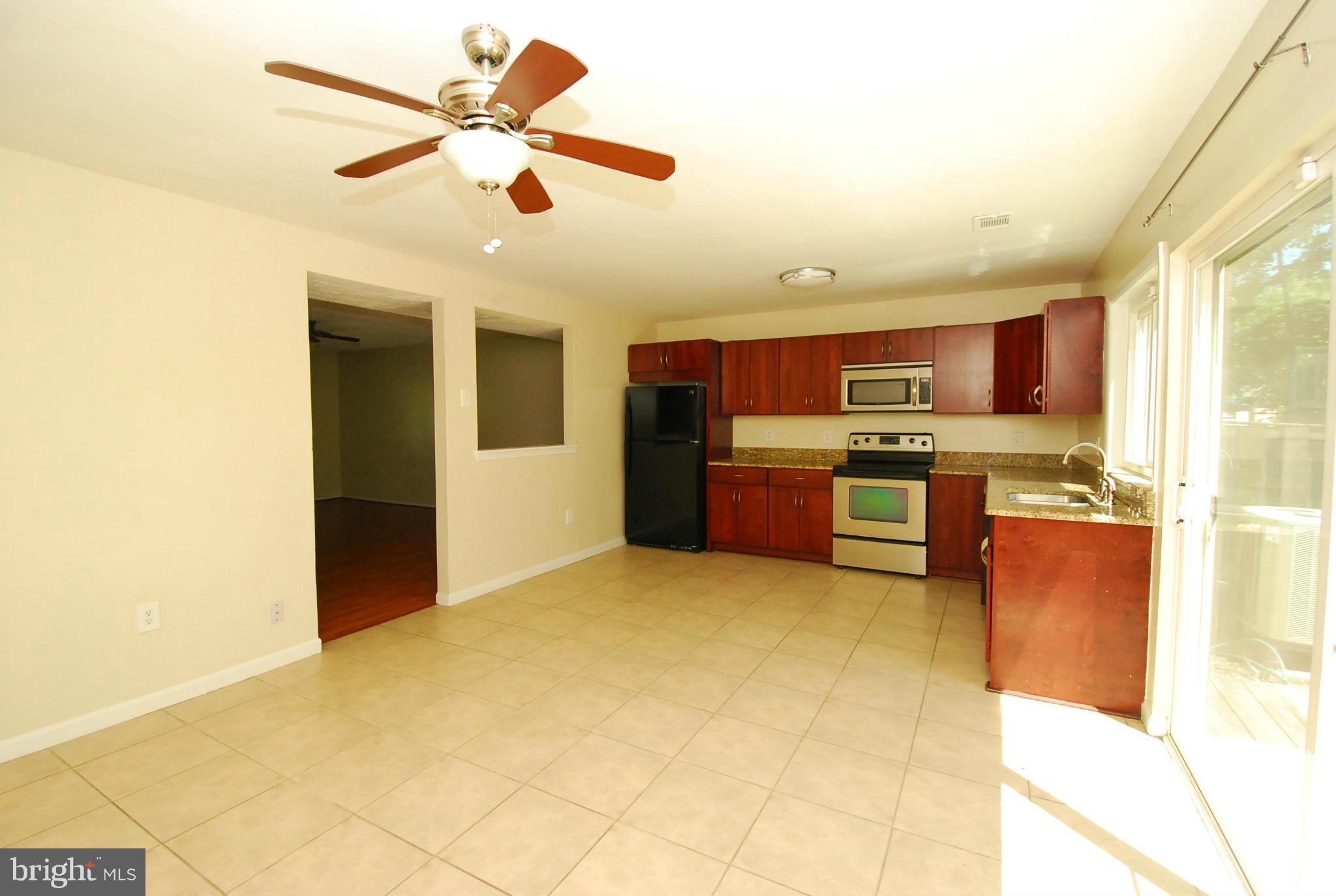 9134 Centerway Road Gaithersburg, MD 20879 - Photo 6 of 18 a kitchen with stainless steel appliances granite countertop a stove cabinets and living room view