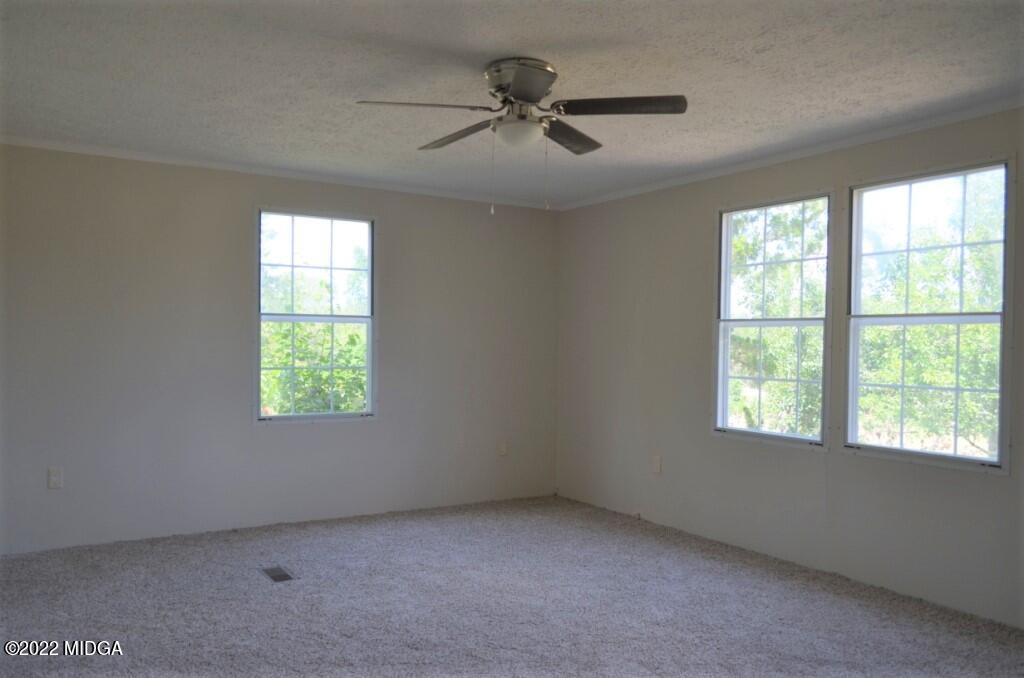 171 Dillon Road Butler, GA 31006 - Photo 12 of 22 an empty room with a window and a fan