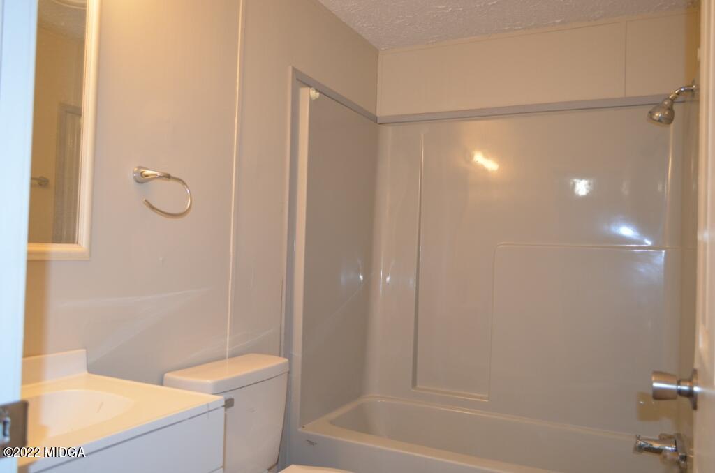 171 Dillon Road Butler, GA 31006 - Photo 18 of 22 a bathroom with a granite countertop bathtub shower and toilet