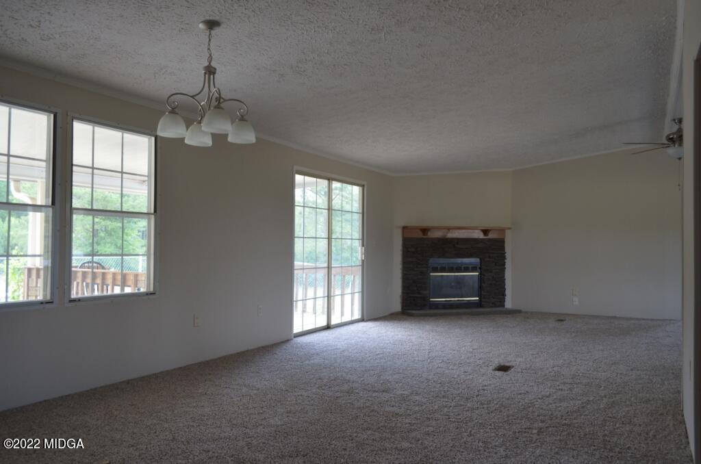 171 Dillon Road Butler, GA 31006 - Photo 4 of 22 a big room with windows and a chandelier
