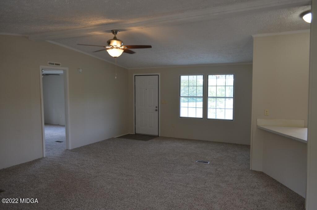 171 Dillon Road Butler, GA 31006 - Photo 5 of 22 an empty room with chandelier fan and windows