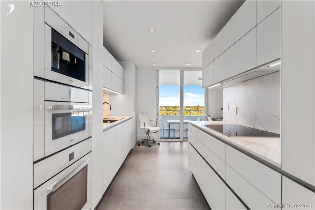 2001 Southeast Sailfish Point Boulevard, Unit 412 Stuart, FL 34996 - Photo 12 of 54 a kitchen with a sink and white cabinets