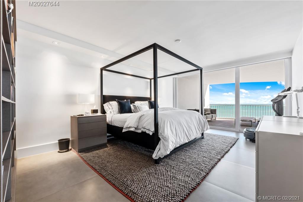 2001 Southeast Sailfish Point Boulevard, Unit 412 Stuart, FL 34996 - Photo 14 of 54 a bed room with a bed and a couch