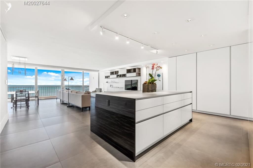 2001 Southeast Sailfish Point Boulevard, Unit 412 Stuart, FL 34996 - Photo 6 of 54 a kitchen with a refrigerator and table chair