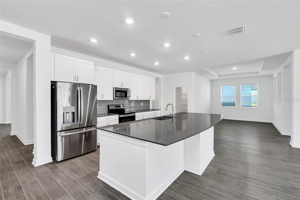 5768 Stephens Road St. Cloud, FL 34771 - Photo 7 of 50 a kitchen with kitchen island a counter top space cabinets and stainless steel appliances