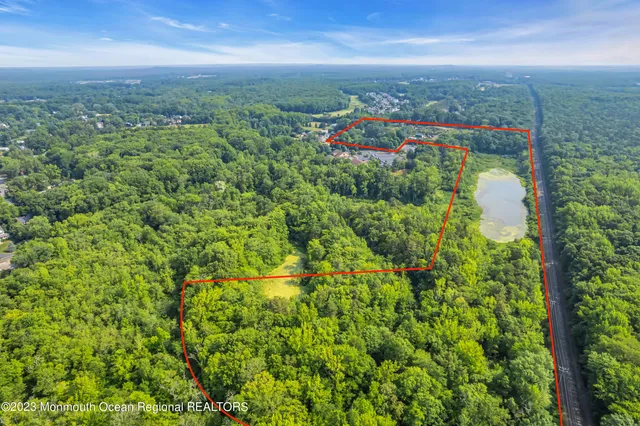 an aerial view of residential houses with outdoor space and trees