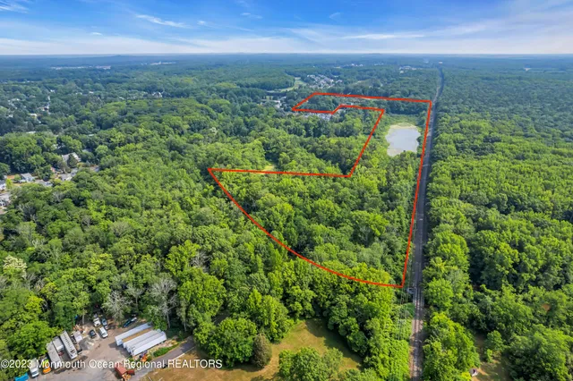 an aerial view of residential houses with outdoor space and trees