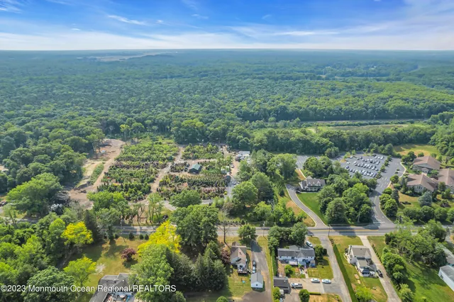 an aerial view of residential houses with outdoor space and trees