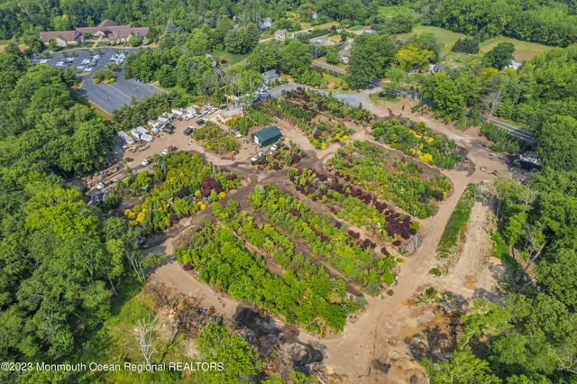 an aerial view of residential houses with outdoor space and trees