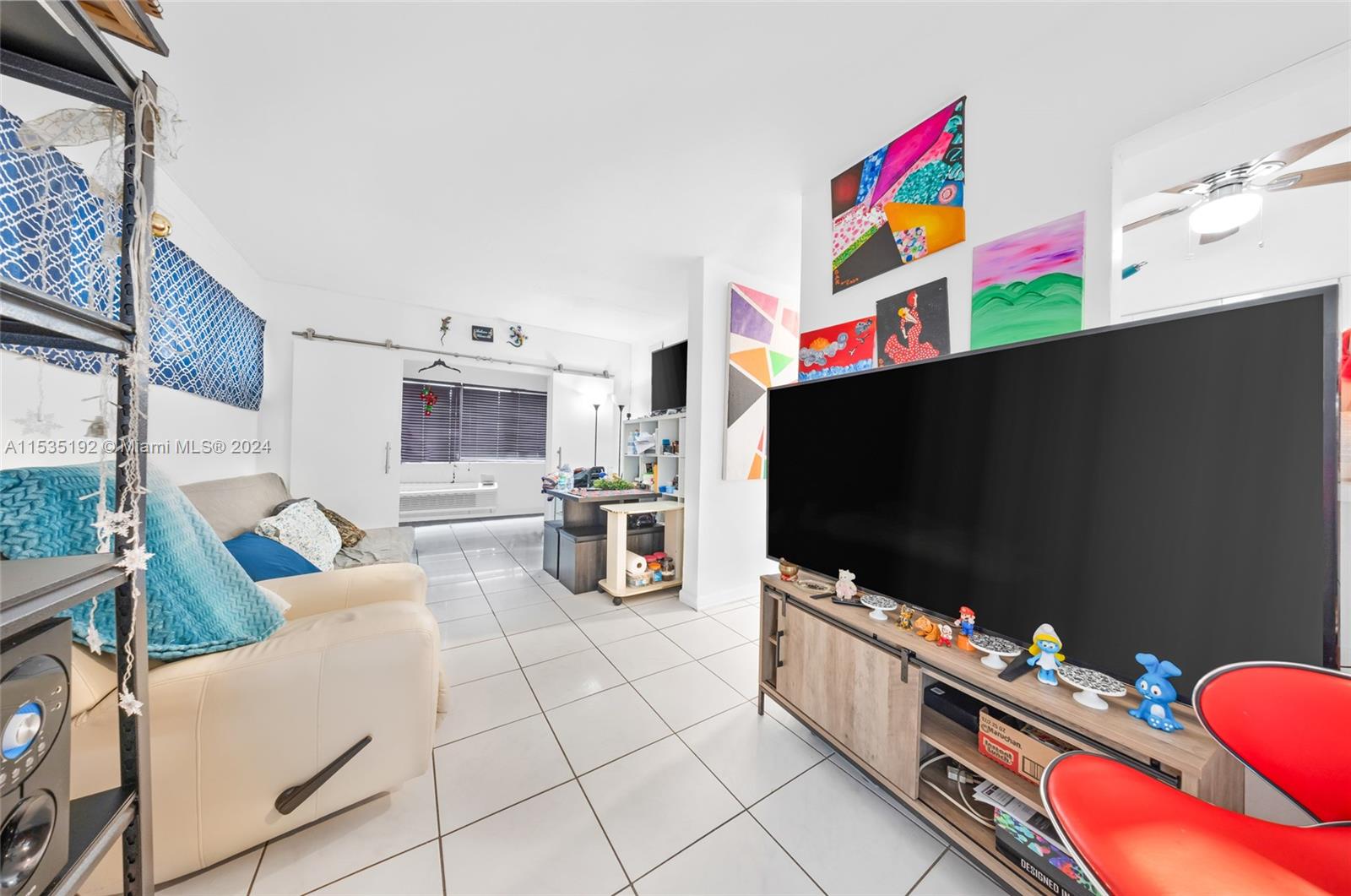 235 78th Street Miami Beach, FL 33141 - Photo 27 of 36 a living room with furniture and a flat screen tv